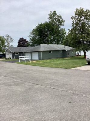 A single-story building with a garage, a lawn, and trees in the background.