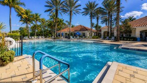 A swimming pool with a clear blue water, surrounded by palm trees and lounge chairs. - Live the Naples Lifestyle.. Resort Amenities & Coastal Charm (Naples)