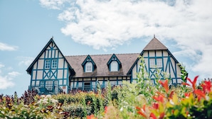 A traditional half-timbered house with a symmetrical facade, multiple windows, and a central chimney. - Aesthetic Normandy House for 6 With Pool (Houlgate)