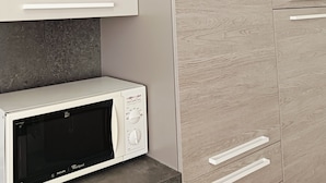 Cozinha com micro-ondas, armários e bancada.