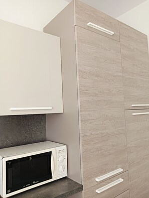 A kitchen with a microwave, cabinets, and a countertop. - Aaron Guest House perfect for experiencing the city with comfort, style and convenience. (Venezia)