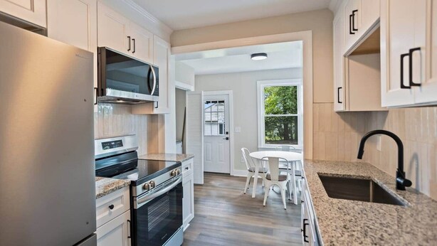 A kitchen with a built-in oven, microwave, and granite countertop. - 3BR Augusta Retreat Near Medical, VA & Downtown (Augusta)