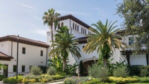 A white building with a tiled roof, surrounded by well-maintained gardens and palm trees. - Florida Holiday! 1 Bedroom, 1 Bath Villa - Marriott’s Lakeshore Reserve, Orlando (Orlando)