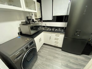 A modern kitchen with a stainless steel refrigerator, a built-in washer, and a coffee maker. - Beautiful apartment near Angel de la Independencia (Cuauhtémoc)