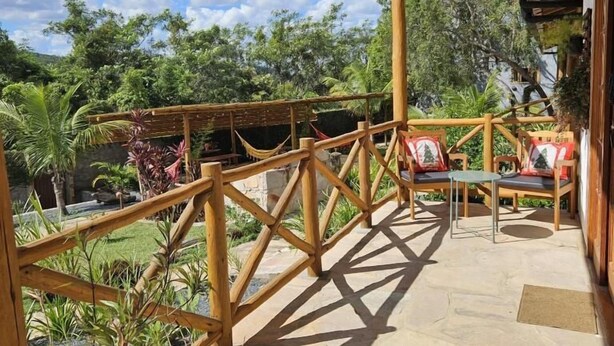 Une terrasse extérieure avec une clôture en bambou, un revêtement de sol en pierre et du mobilier d’extérieur.
