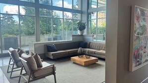 En moderne stue med et stort vindue, en sofa, et sofabord og en lænestol.