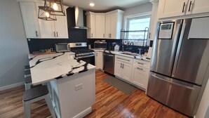A modern kitchen with white cabinets, a stainless steel refrigerator, a built-in oven, and a microwave. - Near Everything, Seaside Hgts/Ortley Beach (Seaside Heights)