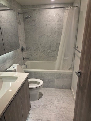 A bathroom with a bathtub, toilet, and sink.