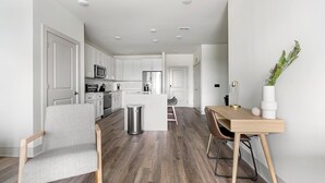 Een moderne keuken met witte kastjes, roestvrijstalen apparatuur en een centraal eiland.