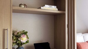 A room with a built-in desk, a laptop, a chair, a bookshelf, and a bed with pillows. - Cozy Studio A/C 1P - Arc de Triomphe (Paris)