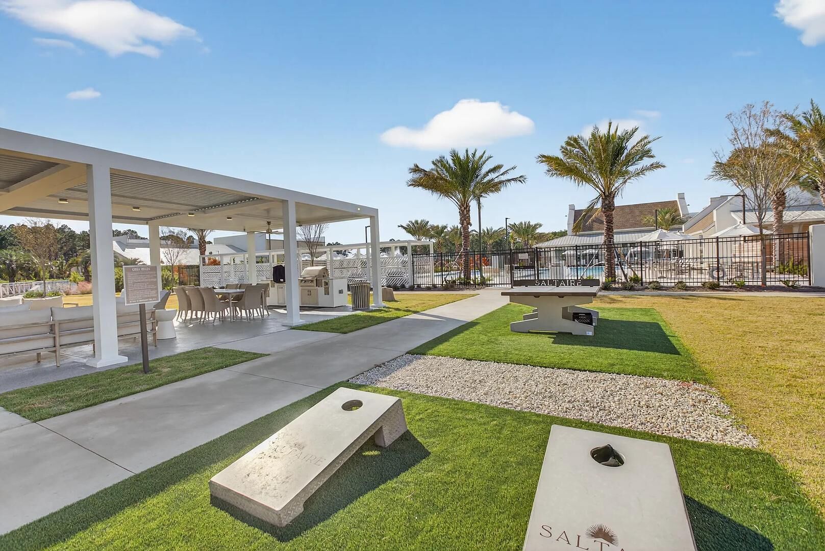 An outdoor patio area with a covered seating area, a grill, and a sign that reads 'SALTAIRE.'