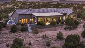A modern house with a large patio, a swimming pool, and a view of the surrounding landscape. - Santa Fe Design Home · Stargazing Dome, Sauna, Cold Plunge & Mountain Views (Santa Fe)
