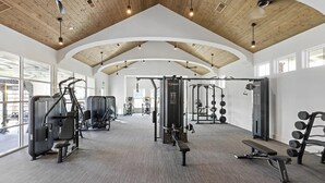 A gym with ceiling fans, exercise equipment, and large windows. - Landing | Stylish 2BD, Gym (Santa Rosa Beach)