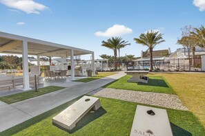 An outdoor patio area with a covered seating area, a grill, and a sign that reads 'SALTAIRE.' - Landing | Stunning 2BD, Gym (Santa Rosa Beach)