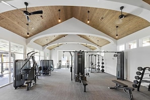A gym with ceiling fans, exercise equipment, and large windows. - Landing | Stylish 2BD, Gym (Santa Rosa Beach)
