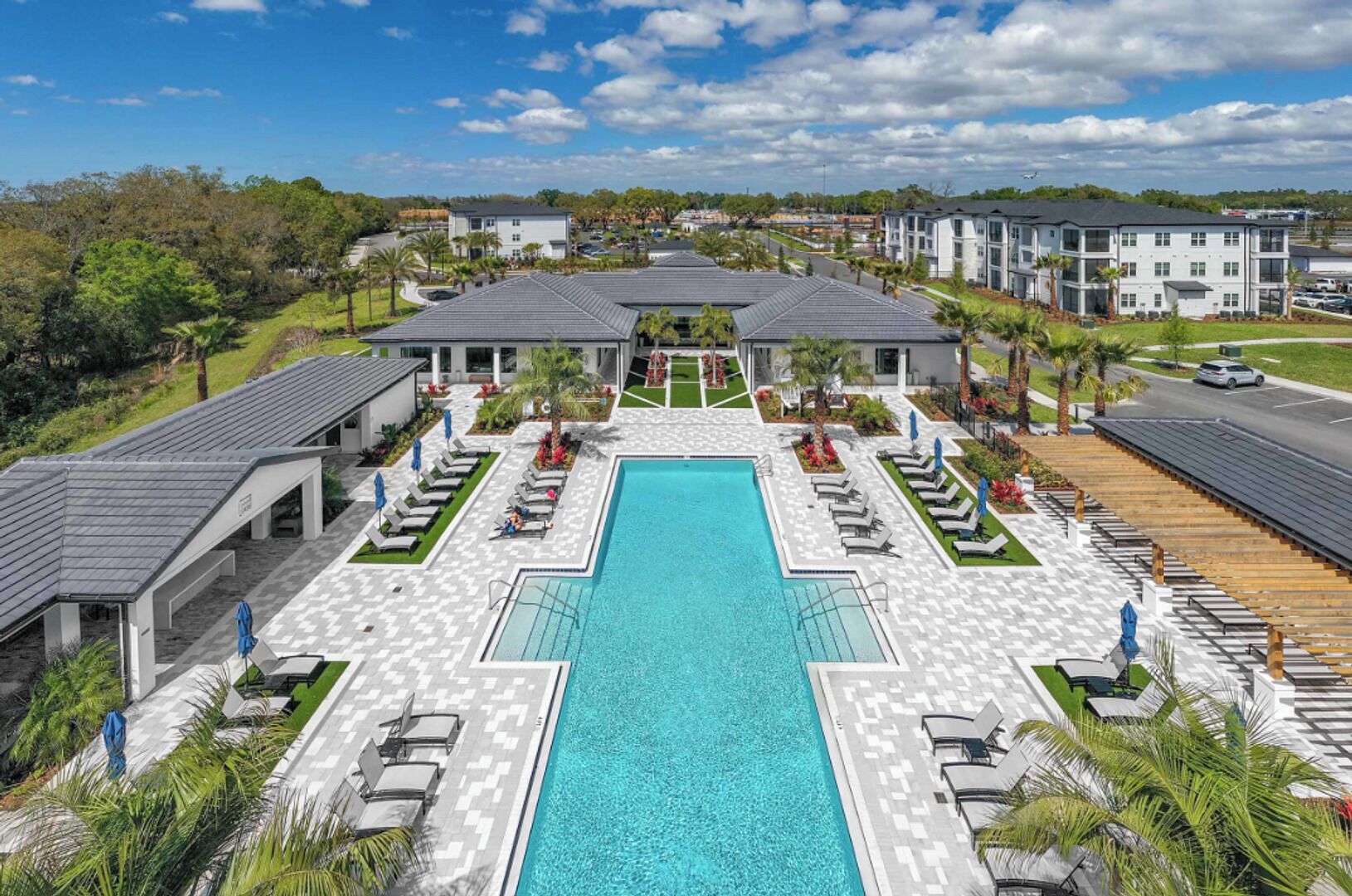 A large swimming pool with sun loungers and a covered patio area.