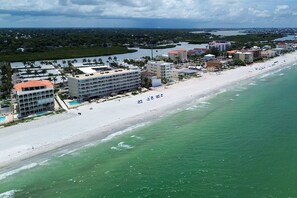 A coastal hotel with multiple buildings, a beach, and a marina.