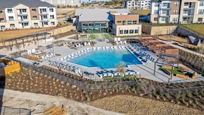A modern apartment complex with a central swimming pool, outdoor seating areas, and a landscaped garden. - Landing | Amazing 1BD, Gym, Clubhouse (Dallas)