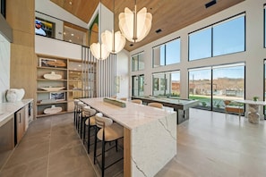 A modern kitchen with a marble island, bar stools, and a pool table. - Landing | Amazing 1BD, Courtyard, Gym (Dallas)