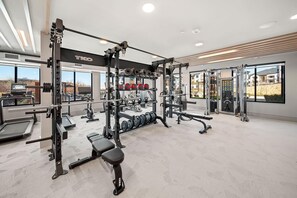 Ein Fitnessraum mit Gewichten, Laufbändern und Bänken.