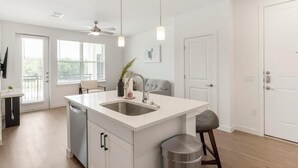 Una cucina moderna con isola centrale, lavastoviglie e ventilatore a soffitto.