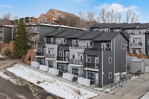 Ein mehrstöckiges Wohngebäude mit Balkonen, ein Ziegelbau auf verschneitem Grund.