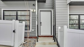 A modern building with a white door, a mailbox, and a small tree in the entrance. - Modern Villa in the heart of Crescent Heights (Calgary)