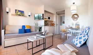 Una sala moderna con un sofá, una mesa de comedor y una zona de cocina.