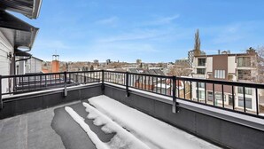 A balcony with a metal railing, a view of the cityscape, and a building with a tower. - Work away from home! Crescent Heights. (Calgary)
