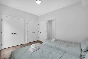 A hotel room with a large bed, a wardrobe, and a door leading to another room. - Work away from home! Crescent Heights. (Calgary)