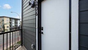 Um edifício com porta preta, caixa de correio e luminária.
