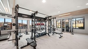 Una palestra con attrezzi per sollevamento pesi, tapis roulant e panche.