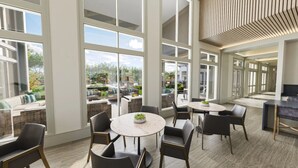 A spacious indoor area with large windows, a round table with chairs, and a view of the outdoor patio. - Landing | Amazing 1BD in Northwest Side (San Antonio)