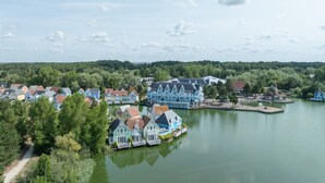 A lakeside village with houses along the water, a dock, and a path leading to the water. - Retreat Near the Baie de Somme (Fort-Mahon-Plage)