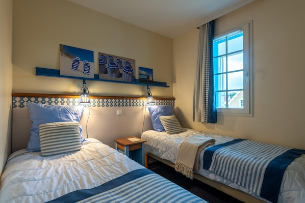 A room with two beds, a window with curtains, and wall art. - Retreat Near the Baie de Somme (Fort-Mahon-Plage)