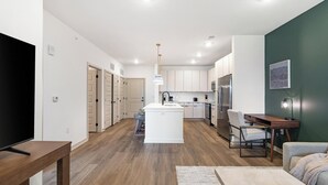 Ein modernes Apartment mit Küche, Essbereich und Wohnzimmer.