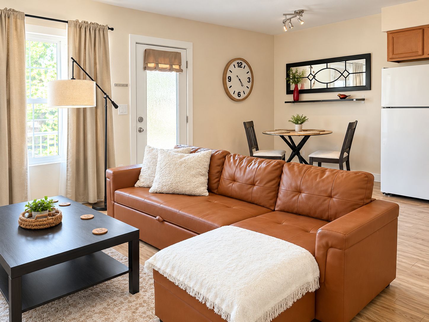 A living room with a brown leather sofa, a small table with a plant, and a white throw blanket.