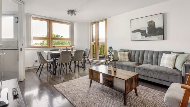 A spacious living area with a sofa, coffee table, and dining table. - Chelsea Riverside 4-Bed · Sleeps 10 · Workspace (Greater London)