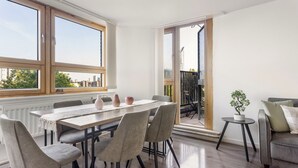 A dining area with a table, chairs, and a view through a glass door to an outdoor space. - Chelsea Riverside 4-Bed · Sleeps 10 · Workspace (Greater London)
