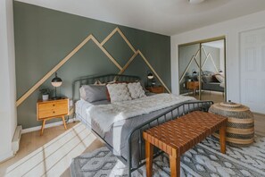 A bedroom with a bed, bedside tables, a bench, a mirror, and a patterned rug. - Private Heated Pool | Hot Tub | Game Room (Blakeslee)
