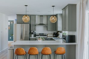 A modern kitchen with a central island, stainless steel appliances, and pendant lighting. - Private Heated Pool | Hot Tub | Game Room (Blakeslee)