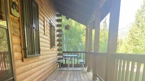 Eine Holzterrasse mit Geländer, Tisch und Bank.