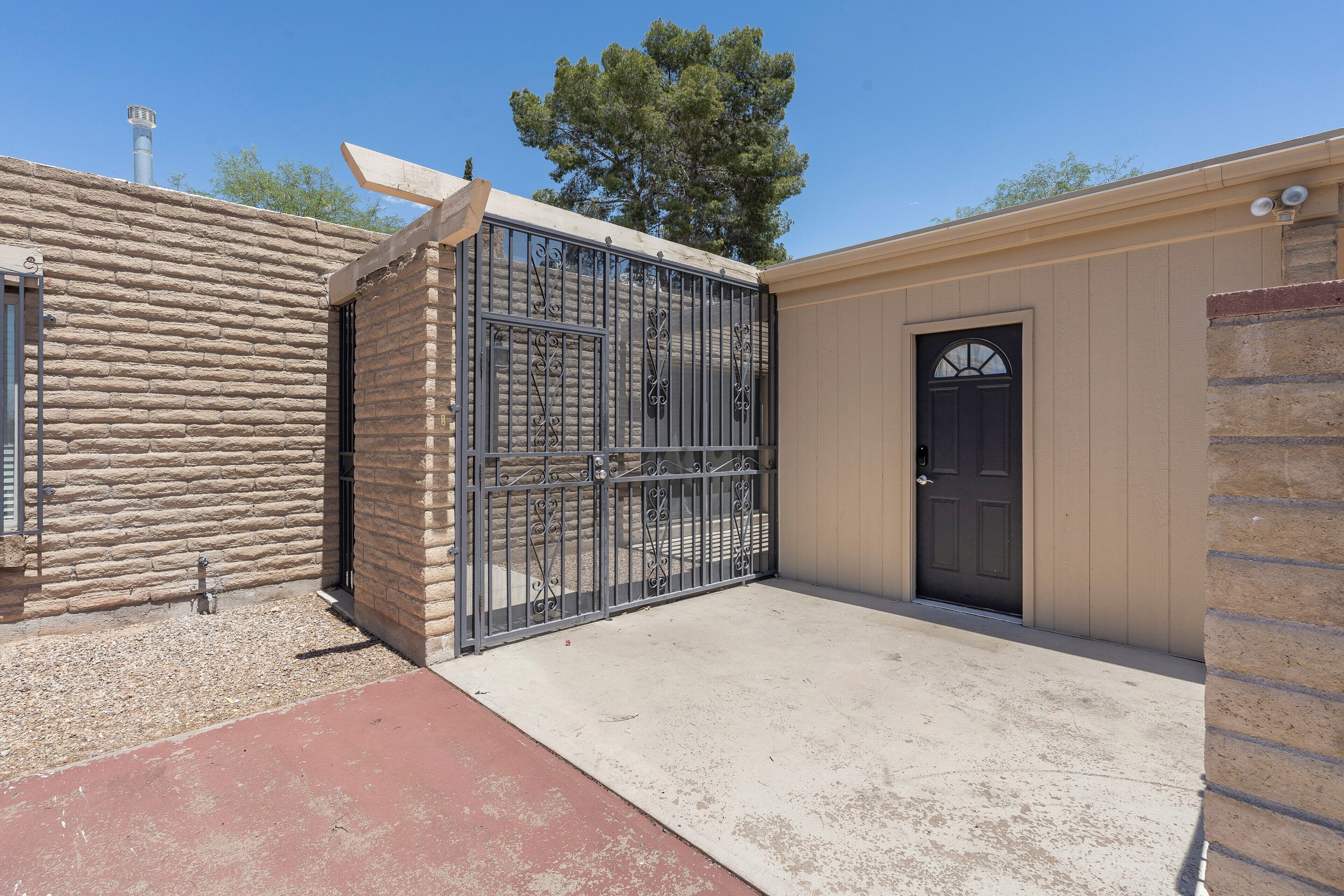 A building with a stone facade, a metal gate, and a door.