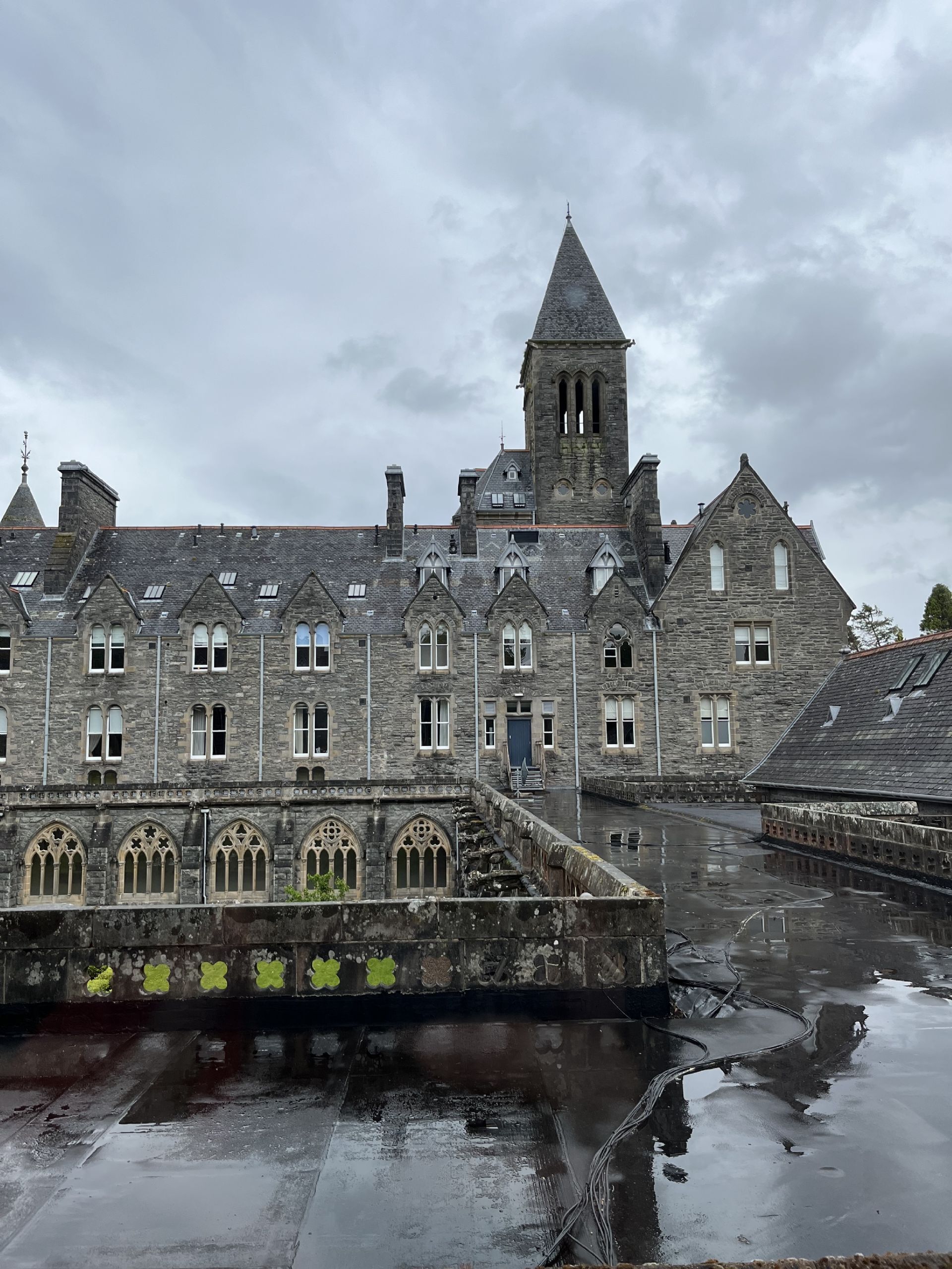 Een historisch gebouw van steen met veel ramen en een opvallende toren.