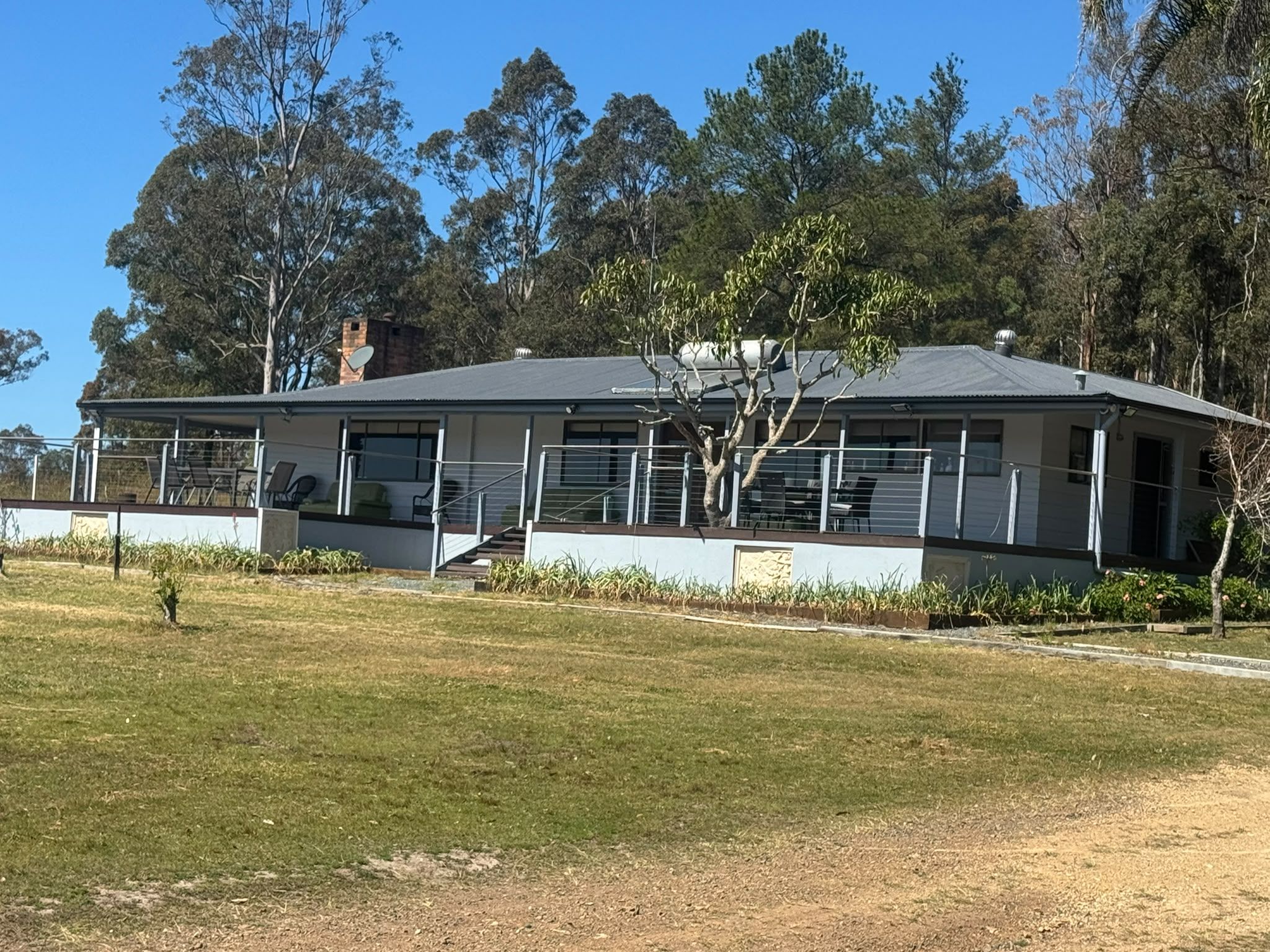 A two-story house with a flat roof, large windows, and a fenced yard.