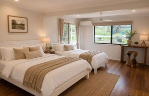 A bedroom with two beds, a window, a ceiling fan, and a bedside table with a lamp. - Scenic Country Escape Peaceful 4BR Farm Stay (Nabiac)