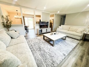 A modern living room with a sofa, coffee table, and a television.