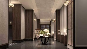 Un pasillo moderno de hotel con paneles de madera, suelo pulido e iluminación empotrada.