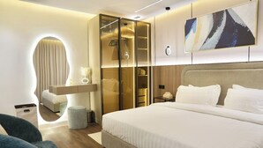 A modern bedroom with a large bed, a walk-in closet, and a unique circular window. - Cozy 1-bedroom apartment in Almlaqa Riyadh with coffee bar (Riyadh)