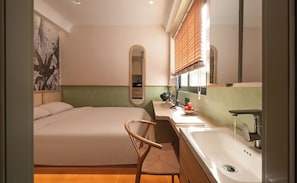 A hotel room with a bed, a chair, a sink, and a mirror. - Phuc Loc Premier (Ben Thanh)